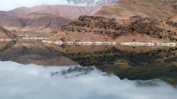 Veduta aerea di un lago di montagna circondato da scogliere epiche in una giornata nuvolosa. Costa rocciosa. Acqua dolce — Video Stock