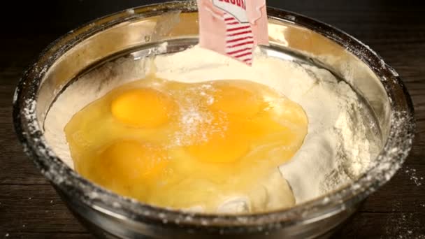 Primer plano de la torta casera o la cocción de galletas. Cocción deliciosa y saludable sin productos químicos. La vainilla se añade al tazón con harina y huevos — Vídeo de stock