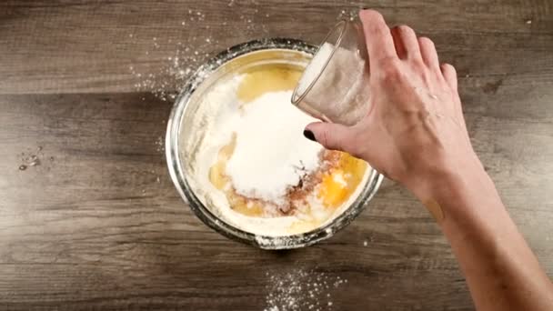 自家製ケーキやビスケット料理のクローズアップ。化学薬品なしでおいしいと健康的なベーキング。女性の手は、小麦粉と卵でボウルにガラスから砂糖を追加します。上からの眺め — ストック動画