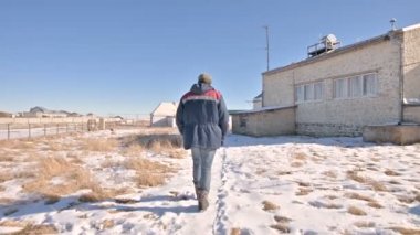 Kot ve sıcak bir üniforma bir erkek araştırmacı takip güneş Gözlemevi bilimsel binalar arasında bir kış güneşli bir gün kar üzerinden yürüyüş. Bilimsel Araştırma İstasyonu
