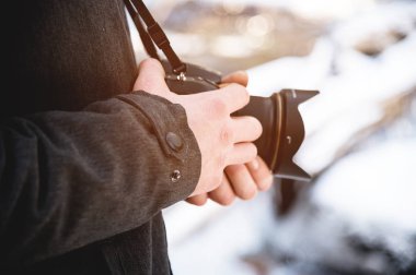 Kış ormanında erkek ellerde yakın çekim profesyonel dijital ayna kamera. Fotoğraf seyahat konsepti