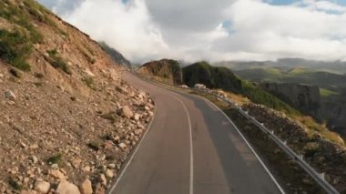 Derin bir geçitte bir dağ asfalt yol serpantin ile bir manzara üzerinde yakın çekim uçan havadan görünümü. Uzak dağlık alanlarda ulaşım iletişimi kavramı