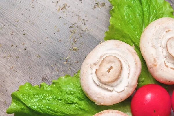 어두운 나무 테이블에 토마토와 녹색 샐러드 잎 흰색 버섯의 클로즈업. 채식 건강 식품 — 스톡 사진