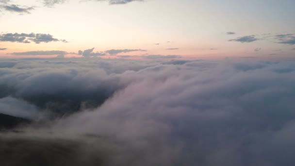 Vista aérea de baja altura vuelo nocturno sobre nubes y colinas en las montañas a la hora azul después de la puesta del sol. El concepto de fiesta nocturna y vuelos nocturnos fondo nublado. Movimiento hacia atrás — Vídeo de stock