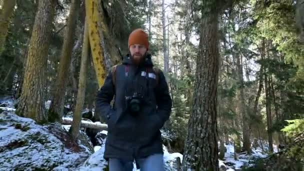 Brodaty mężczyzna podróżnik fotograf z aparatem w lesie zimowym ma Zdjęcia natury. Koncepcja podróży dla blogerów i artystów fotograficznych — Wideo stockowe