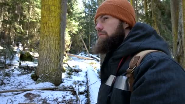 Een bebaarde mannelijke reiziger fotograaf met zijn camera in het winter bos neemt foto's van de natuur. Reis concept voor bloggers en foto artiesten — Stockvideo