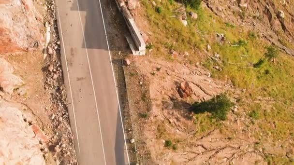 Aerial view low flying close-up on a landscape with a mountain asphalt road serpentine in a deep gorge. The concept of transport communications in remote mountainous areas — Stock Video