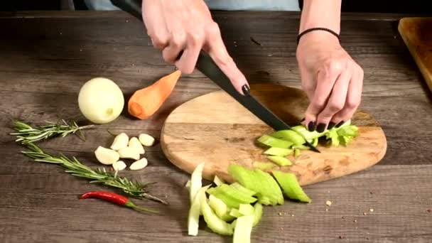 Closeup ženských šéfkuchařových rukou krájení celer na dřevěné řezací desce vedle nakrájené zeleniny. Koncept vegetariánství — Stock video