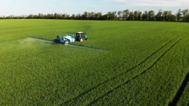 Özel kurulum ile yeşil alan irrigates traktörün havadan görünümü. Pestisitler ve kemirgenler, parazitler ve zararlıları böceklere karşı koruma ile alan büyümeleri püskürtme süreci.