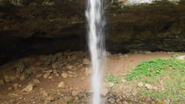 A nyári erdőben a vízeséssel nyíló panorámát is megtekintheti. Víz esik egy szikláról. Tájképi utazás videó emberek nélkül — Stock videók
