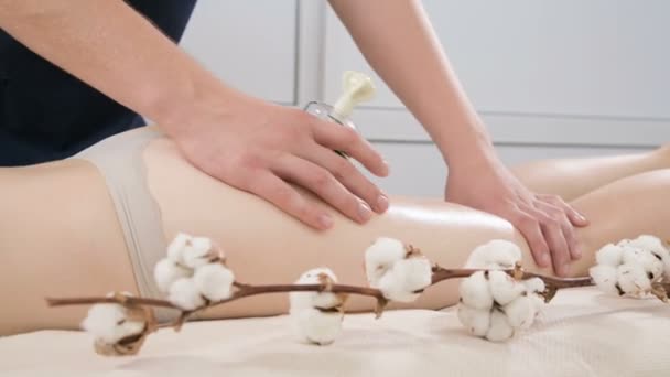 Närbild av en manlig sjukgymnast gör en anti-celluliter kan massage av skinkorna och höfter av en ung kvinna. Begreppet vård och underhåll av hälsan hos den kvinnliga kroppen och huden — Stockvideo