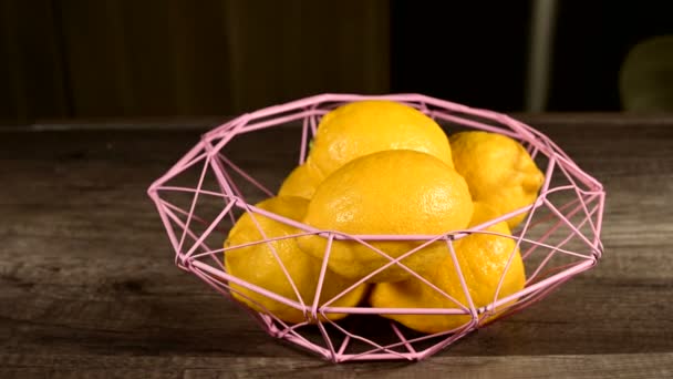 健康饮食和天然产品的概念。成熟的黄色柠檬放在一个柳条碗在一个黑暗的木桌上,在家做饭。特写静生活 — 图库视频影像
