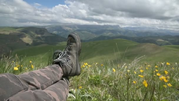 Feche POV de botas de caminhada de um viajante masculino independente no topo de uma montanha, olhando para a vista . — Vídeo de Stock