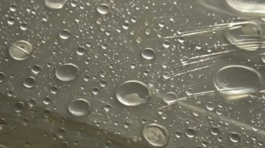 Yüzeyde farklı boyutlarda yağmur damlalarının yakın çekim film sarın kaplı. Nem havası ve nem konsepti