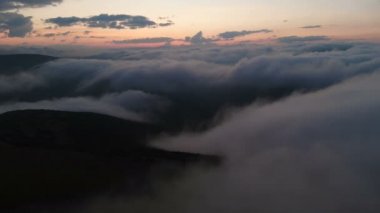 Gün batımından sonra mavi saat dağlarda bulutlar ve tepeler üzerinde düşük anahtar hava görünümü akşam uçuş. Akşam parti ve gece uçuşları kavramı bulutlu arka plan. İleri ye doğru hareket uçuşu