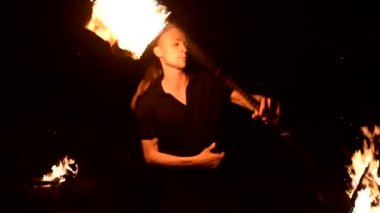 Ateş gösterisi. Adam yanan iki meşaleyle hokkabazlık yapıyor. Gece şovu. Fakirin ustalığı. Close