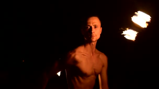 Fire show. Man juwisselt met twee brandende fakkels. Night show. Beheersing van de fakir. Close-up — Stockvideo