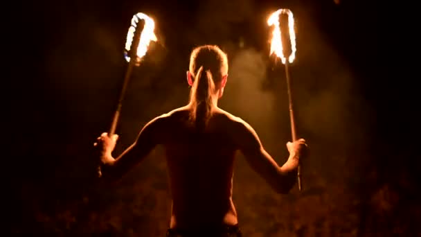 화재 쇼. 남자는 두 개의 불타는 횃불로 저글링. 야간 쇼. 파키르의 숙달. 클로즈업 — 비디오