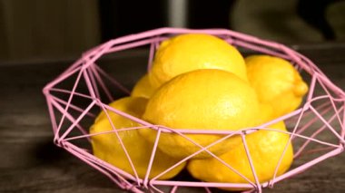 Sağlıklı bir diyet ve doğal ürünler kavramı. Olgun sarı limon koyu ahşap masa ev pişirme bir hasır kase yalan. Yakın çekim hala hayat