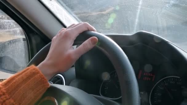 Крупный план женской руки в оранжевом свитере за рулем машины за городом. Медленное движение Женщина водит машину — стоковое видео