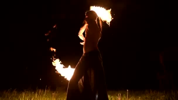 Fire show. Man juggles with two burning torches. Night show. Mastery of the fakir. Low angle — Stock Video