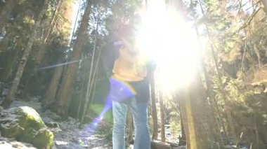 Kamera Takibi bir erkek gezgininin düşük geniş açı arka görünümü bir sırt çantası ile kış aylarında bir konik ormanda bir yol boyunca yürüyüş. Yolunuzu ve seyahat bulma kavramı. ProRes 422 |