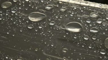 Yüzeyde farklı boyutlarda yağmur damlalarının yakın çekim film sarın kaplı. Nem havası ve nem konsepti