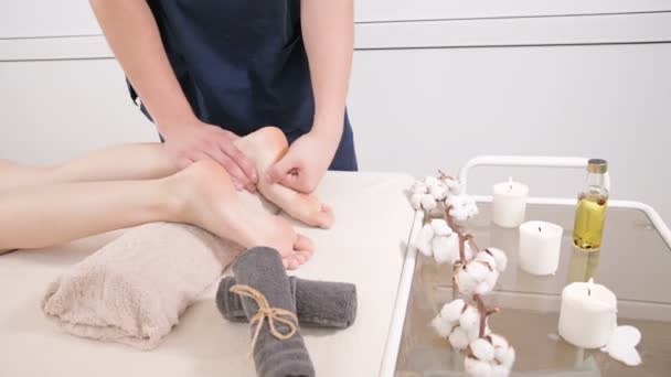 美容と健康スパで若い女性に足とかかとの足マッサージを行う男性理学療法士のクローズアップ。フットケアコンセプト — ストック動画