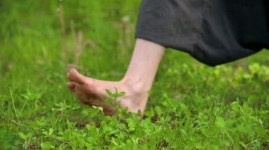 Çimenlerde pratik yapan bir adamın bacaklarının yakın çekim. Qigong egzersizleri çıplak ayak geçiş. Oryantal kültür 4k bir spor yaşam tarzı kavramı
