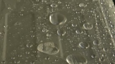 Yüzeyde farklı boyutlarda yağmur damlalarının yakın çekim film sarın kaplı. Nem havası ve nem konsepti