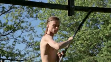 Bir yangın gösterisi için uzun saçlı bir adamın Sabah eğitim vurdu. Yeşil bir ormanın yanında açık havada güneşli bir yaz sabahı meşaleler ve zincirler ile ateş olmadan bir performans için hazırlık.