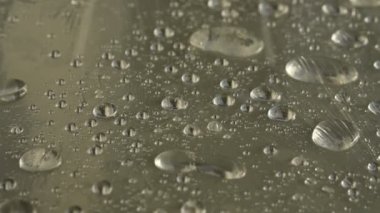 Yüzeyde farklı boyutlarda yağmur damlalarının yakın çekim film sarın kaplı. Nem havası ve nem konsepti
