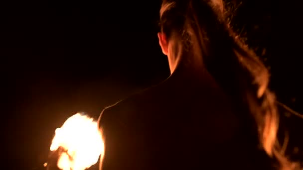 Пожарное шоу. Человек жонглирует двумя горящими факелами. Ночное шоу. Мастерство факира — стоковое видео