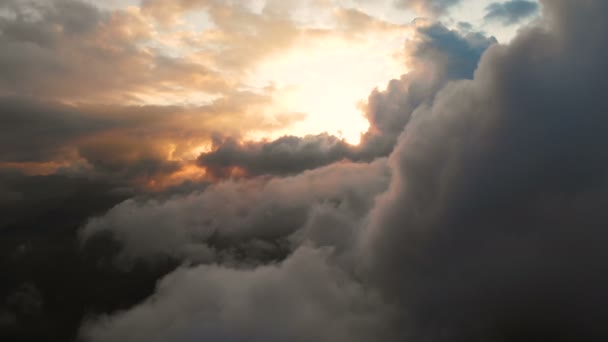 日没時に積雲を通って飛ぶ航空写真。コントラストの高い金色の夕日の曇り。本物の空夢と天気予報の概念 — ストック動画