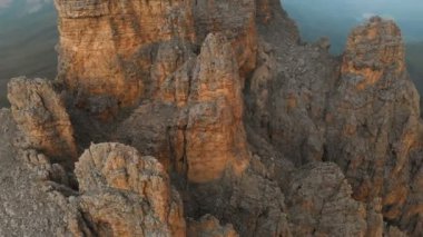 Gün batımında keskin kayalık çıkıntılar üzerinde uçan bir drone havadan görünümü. Aşırı dağcılık için kaya oluşumları Keskin dik dağ. Seyahat video üzerinde Uçuş