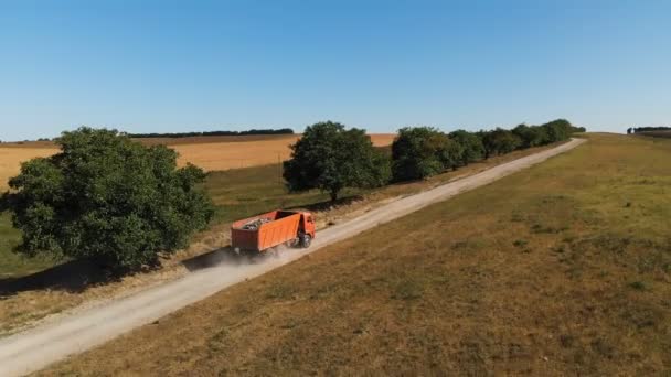 Вид з повітря на вантажівку. Сміттєвоз перевозить будівельні сміття та пісок у вантажівці, їде по сільській дорозі. Вантажоперевезення логістика доставка вантажів — стокове відео