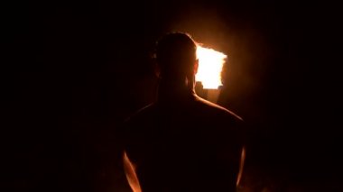 Ateş gösterisi. Adam yanan iki meşaleyle hokkabazlık yapıyor. Gece şovu. Fakirin hakimiyeti