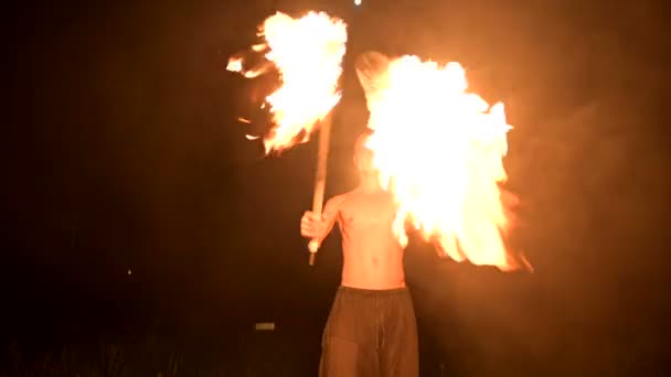Fire show. Man juggles with two burning torches. Night show. Mastery of the fakir — Stock Video