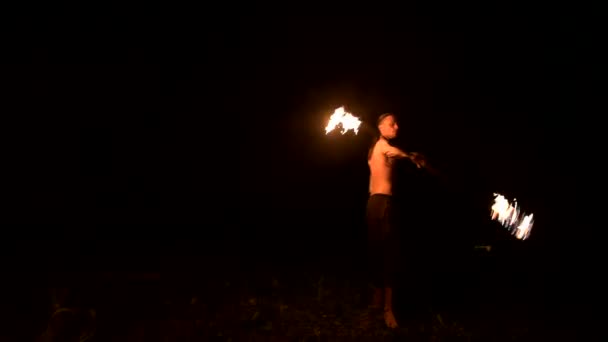 火のショー。男は2つの燃える松明でジャグリング。ナイトショーファキルの習得 — ストック動画
