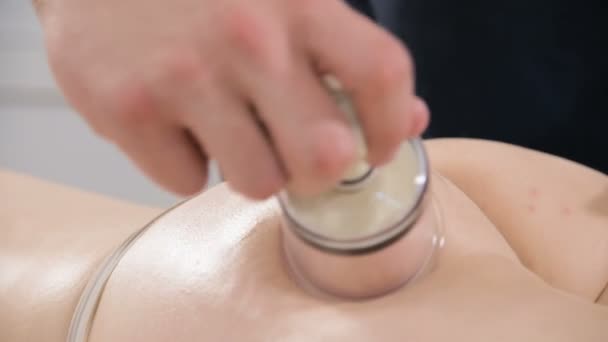 Primer plano de un fisioterapeuta masculino haciendo un anti-celulitis puede masaje de las nalgas y las caderas de una mujer joven. El concepto de cuidado y mantenimiento de la salud del cuerpo y la piel de la mujer — Vídeos de Stock