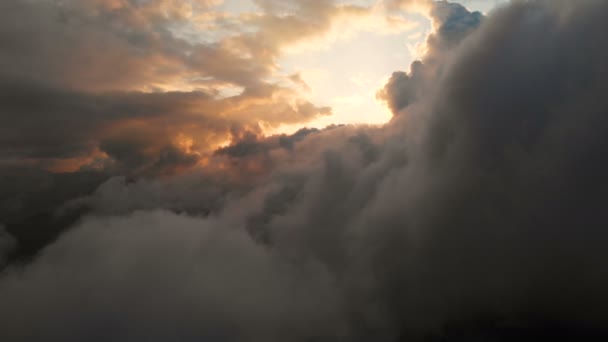 日没時に積雲を通って飛ぶ航空写真。コントラストの高い金色の夕日の曇り。本物の空夢と天気予報の概念 — ストック動画