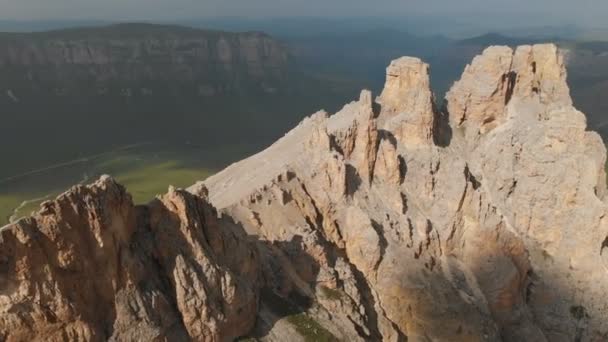 Veduta aerea di un drone che sorvola acuti affioramenti rocciosi al tramonto. Montagna scoscesa e ripida di formazioni rocciose per l'alpinismo estremo. Volo sopra il video di viaggio — Video Stock