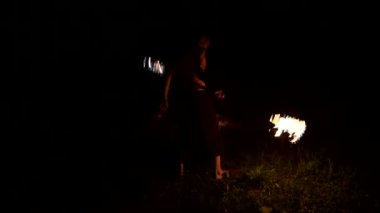 Ateş gösterisi. Adam yanan iki meşaleyle hokkabazlık yapıyor. Gece şovu. Fakirin hakimiyeti