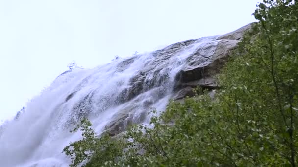 Close-up water drop en spray van een waterval van een stormachtige berg rivier in een groen bos in slow motion met het volgen van bedrading. Het concept van de opwarming van de aarde — Stockvideo