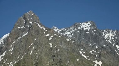 Yaz aylarında kar kalıntıları ile Kafkasya'nın yüksek kayalık dağlarının elleriyle yakın çekim Video panoraması