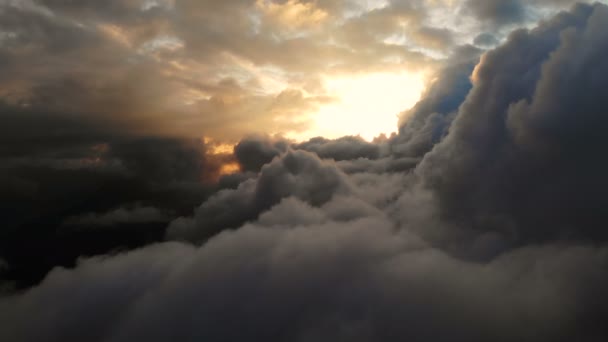 Luftaufnahme, die durch Kumulus-Gewitterwolken bei Sonnenuntergang fliegt. goldfarbene Bewölkung bei Sonnenuntergang in hohem Kontrast. echter Himmel. das Konzept von Träumen und Wettervorhersage — Stockvideo