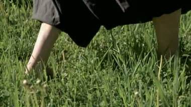 Çimenlerde pratik yapan bir adamın bacaklarının yakın çekim. Qigong egzersizleri çıplak ayak geçiş. Oryantal kültür 4k bir spor yaşam tarzı kavramı