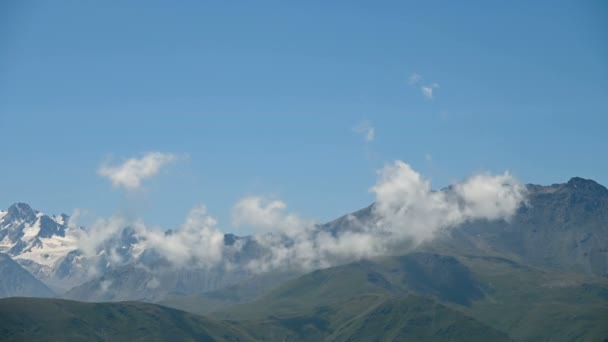 Upływ czasu w ciągu dnia na wyżynach. Skyline z ośnieżonych szczytów górskich w letni słoneczny dzień. Koncepcja zmiany pogody i tworzenia chmur. — Wideo stockowe