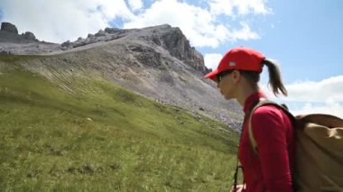 Bir kız fotoğrafçı bulutlar ile kayalar ve gökyüzü arka plan karşı yokuş yukarı gider. Manzara fotoğrafçıları için konsept fotoğraf turları