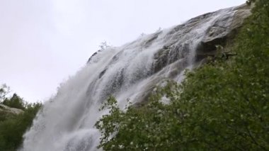 Closeup su damla ve izleme kablolama ile yavaş hareket yeşil bir ormanda fırtınalı bir dağ nehri bir şelale sprey. Küresel ısınma kavramı